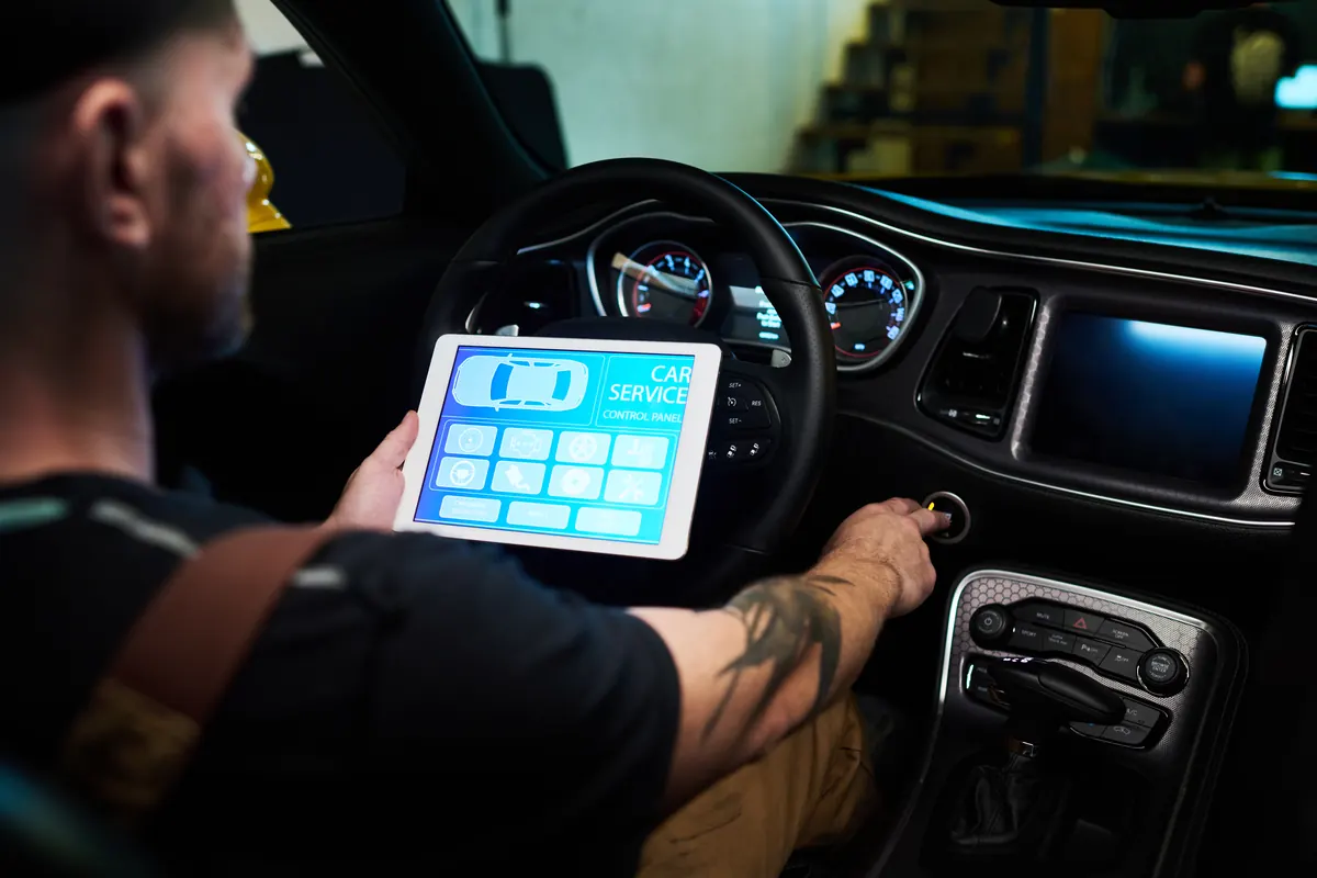 Technicien au volant, tablette de diagnostic à la main