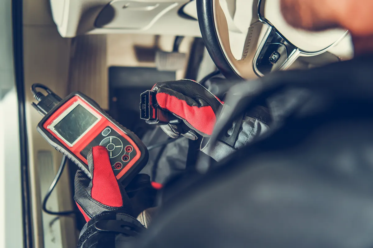 Outil de diagnostic branché dans l’habitacle d’une voiture